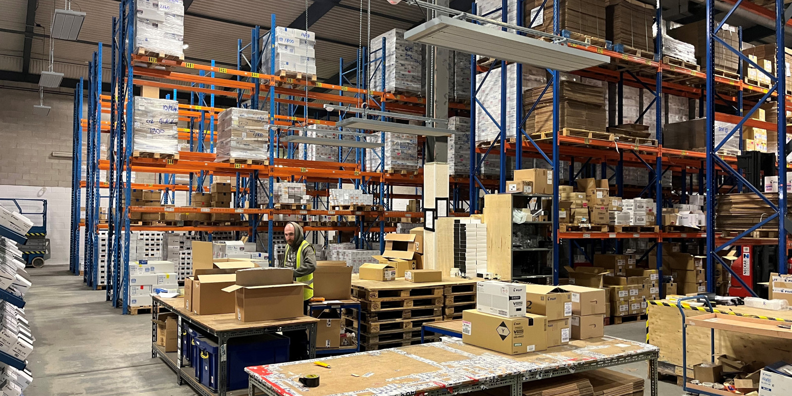 EEZ Medium wave infrared heaters suspended over a packing station in a warehouse