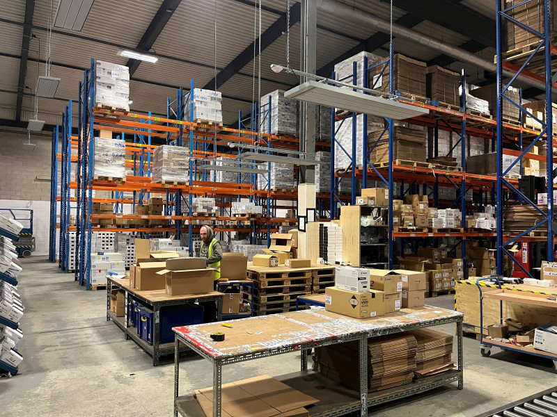 EEZ Medium wave infrared heaters suspended over a packing station in a warehouse