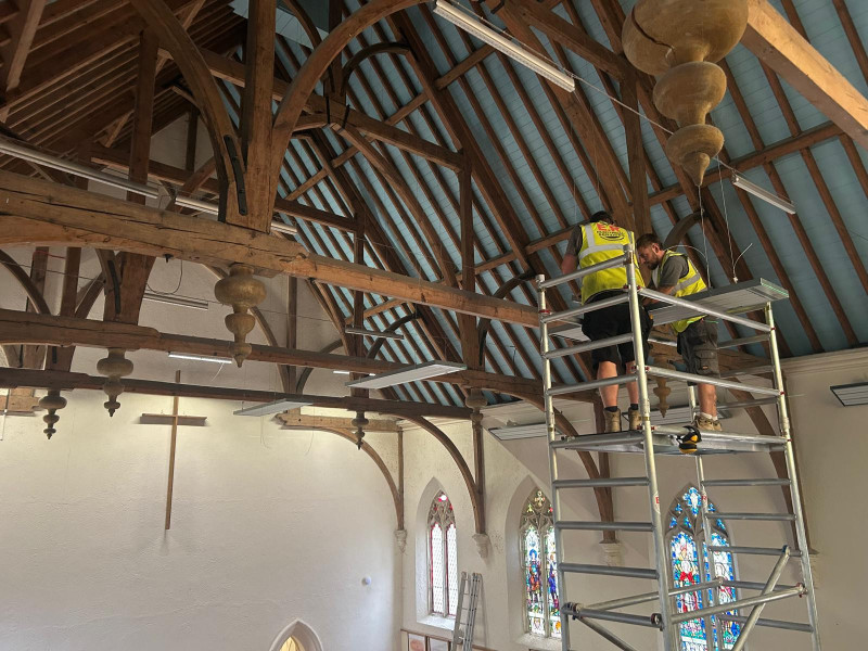ARC Installer partners installing suspended EEZ medium wave infrared heaters in a church
