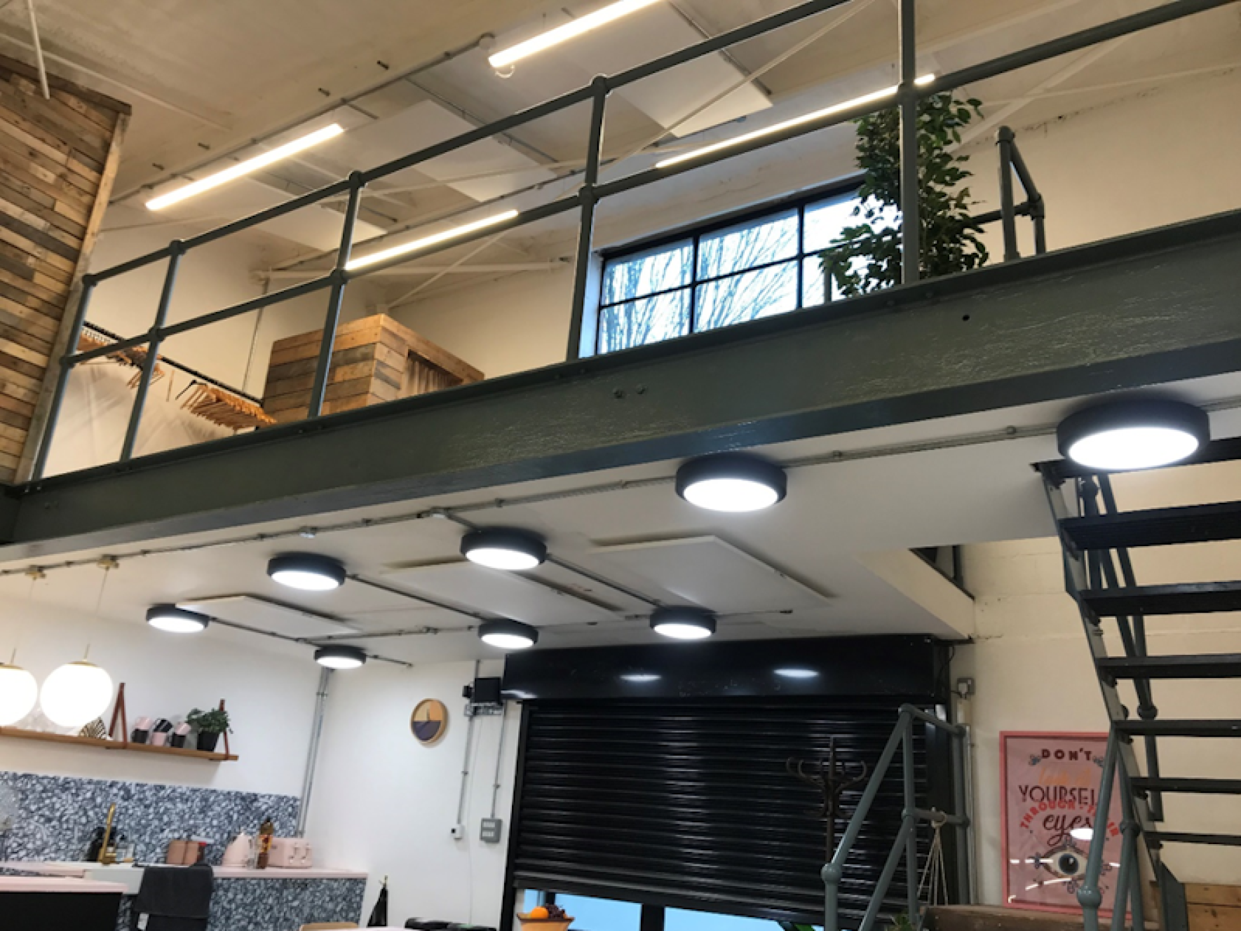 LAVA Basic Panels mounted under a mezzanine by a shutter door in a warehouse space